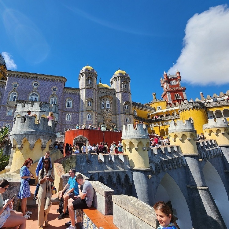 Яркие стены и башни Дворца Пена под синим небом. ✅ Лицензированный гид Португалии