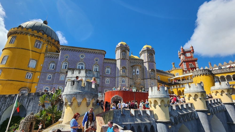 Яркие террасы и башни дворца Пена под синим небом. ⭐ Авторские экскурсии в Синтру ⭐ с профессиональным гидом.