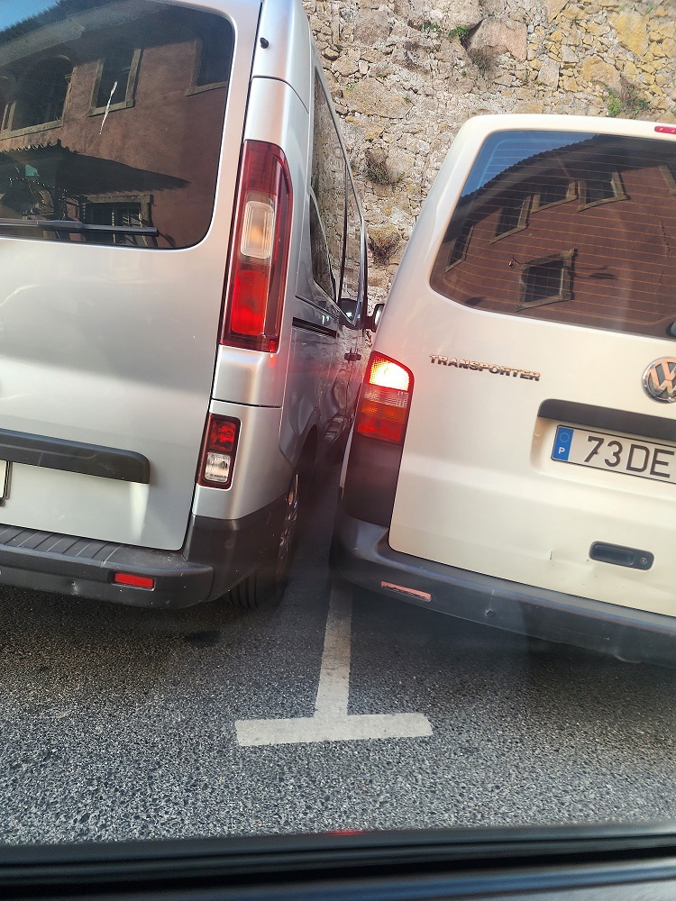 Узкая парковка в Синтре микроавтобусы стоят впритык друг к другу.